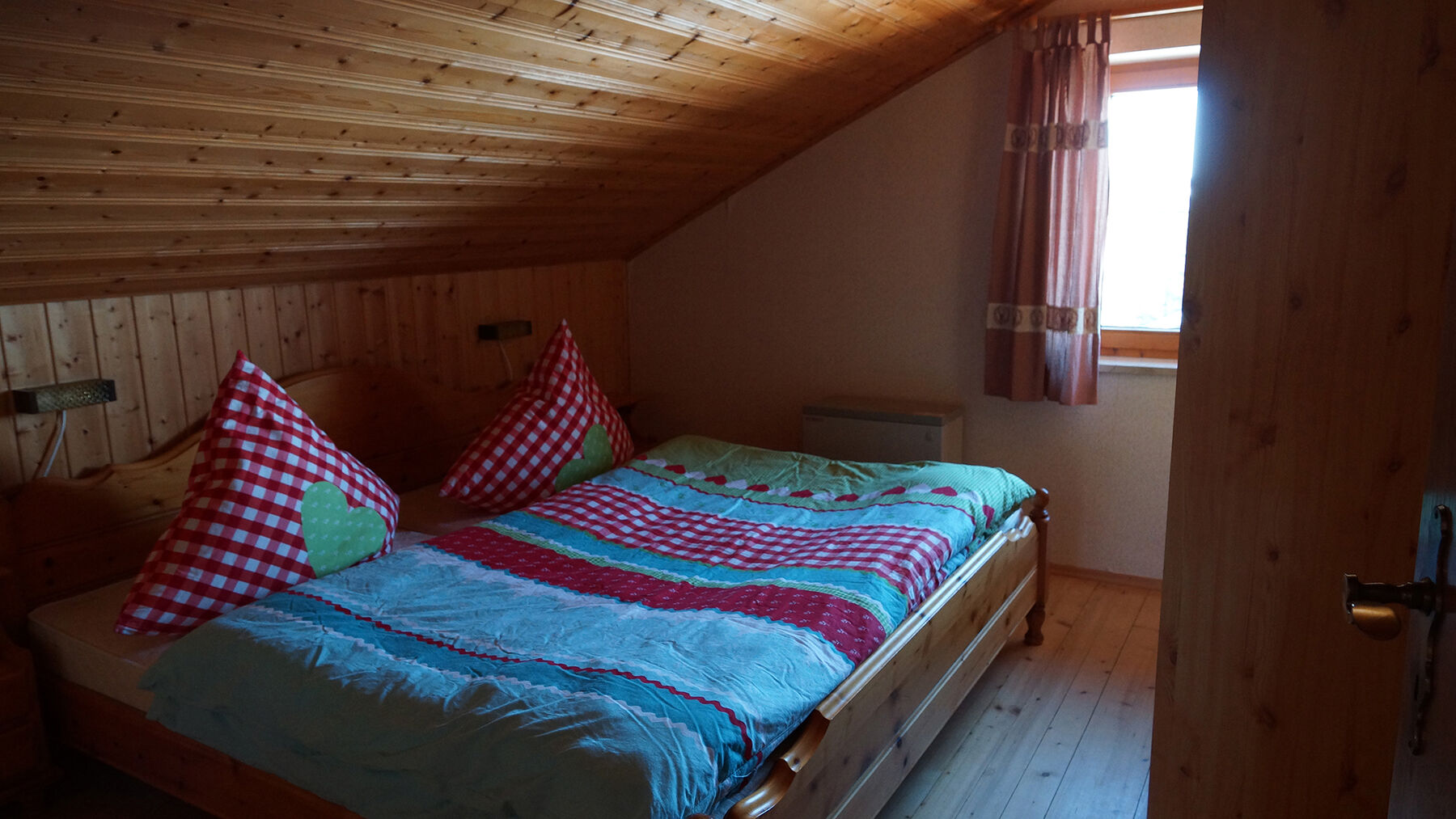 Schlafzimmer 1 DG:Das erste Schlafzimmer im Dach bietet genügend Stauraum für Ihre Kleidung. Die Betten in dem warm eingerichteten Raum versprechen eine angenehme Nachtruhe.